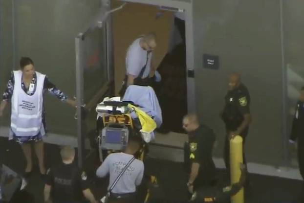 A man placed in handcuffs by police is wheeled on a stretcher into a hospital near Marjory Stoneman Douglas High School following a shooting incident in Parkland