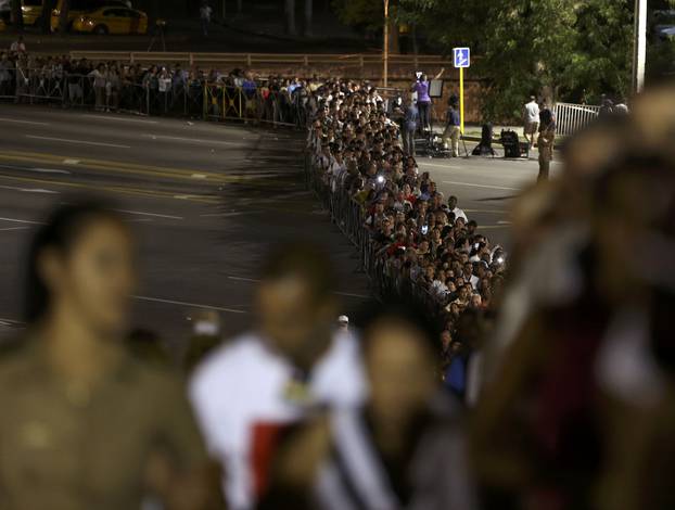 People wait in line to pay tribute to Cuba