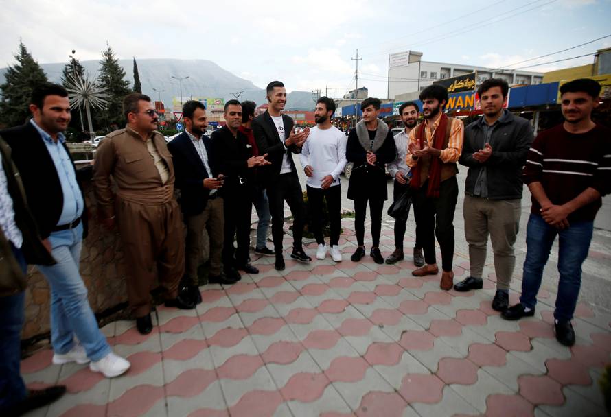Biwar Abdullah, 25, an Iraqi Kurdish local footballer, who looks like the football player Cristiano Ronaldo, takes pictures with people in the district of Soran, northeast of Erbil