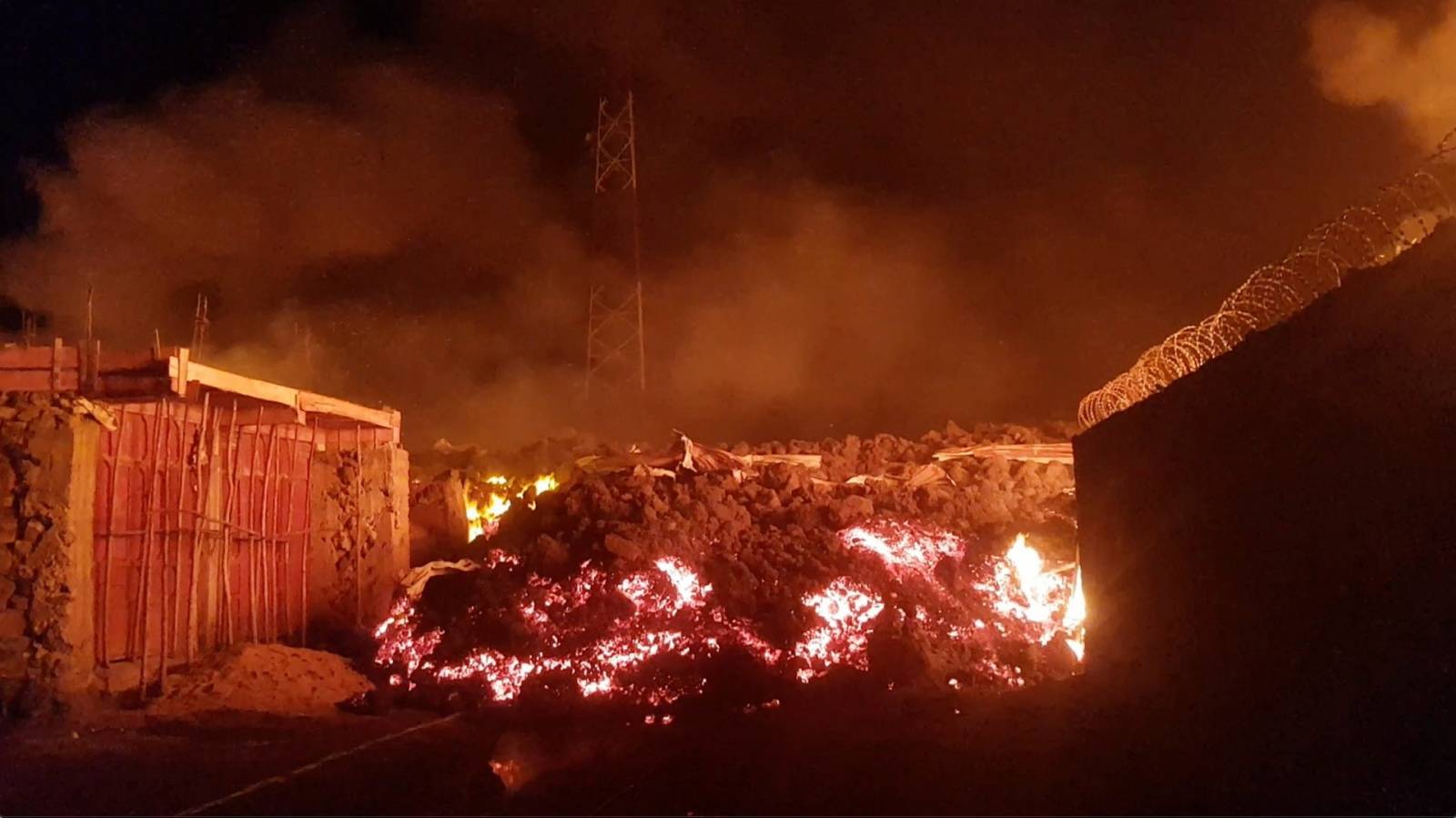 Flowing lava from the volcanic eruption of Mount Nyiragongo is seen between buildings, in Goma