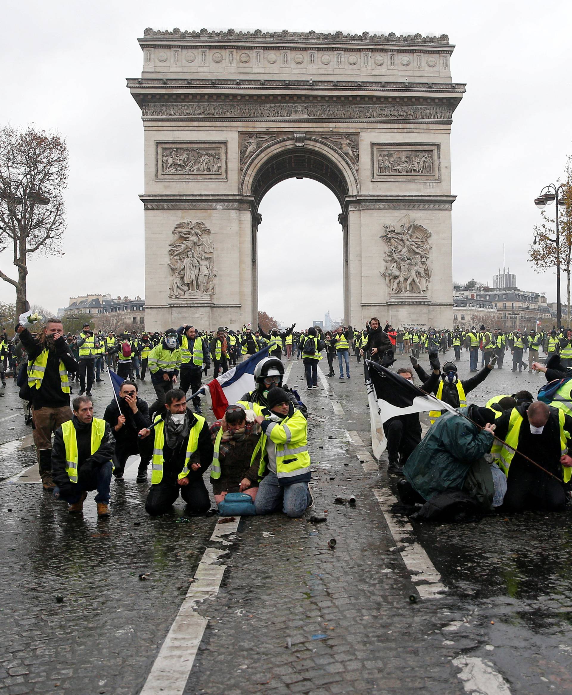 Protesters wearing yellow vests, a symbol of a French drivers' protest against higher diesel taxes, face off with French riot police during clashes at the Place de l'Etoile near the Arc de Triomphe in Paris