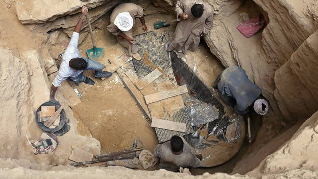 Archaeologists and workers unearth closed coffin containing three mummies with remains of three people in Alexandria