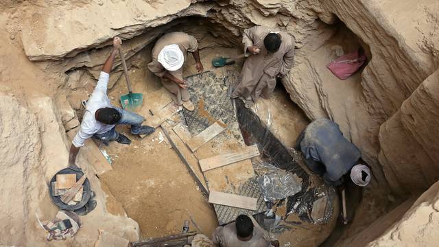 Archaeologists and workers unearth closed coffin containing three mummies with remains of three people in Alexandria