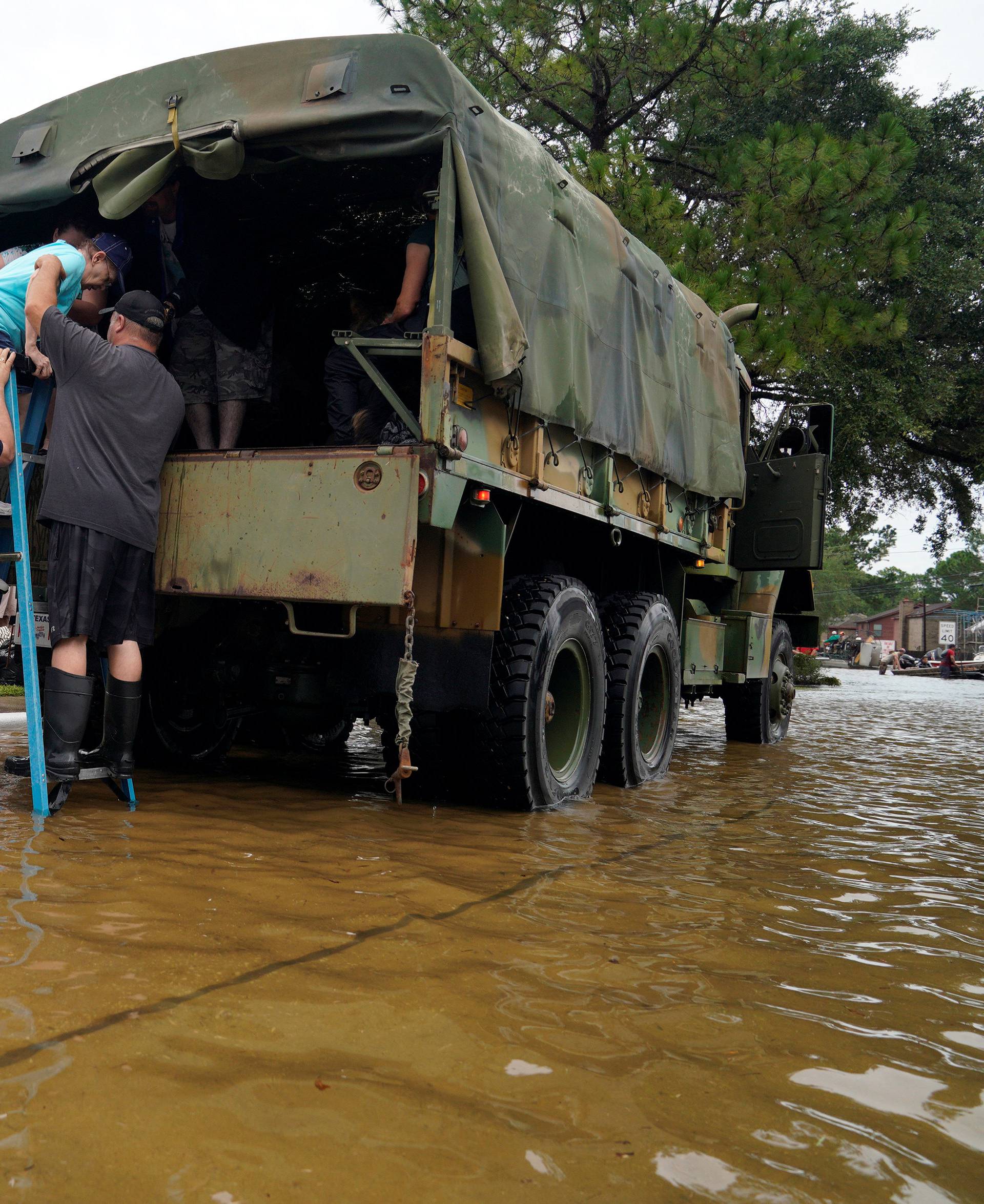 Volunteers load people into a collector's vintage military truck to evacuate them from flood waters from Hurricane Harvey in Dickinson