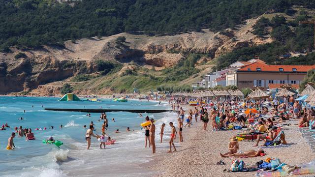 Glavna plaža u Baški puna je posjetitelja koji uživaju u moru