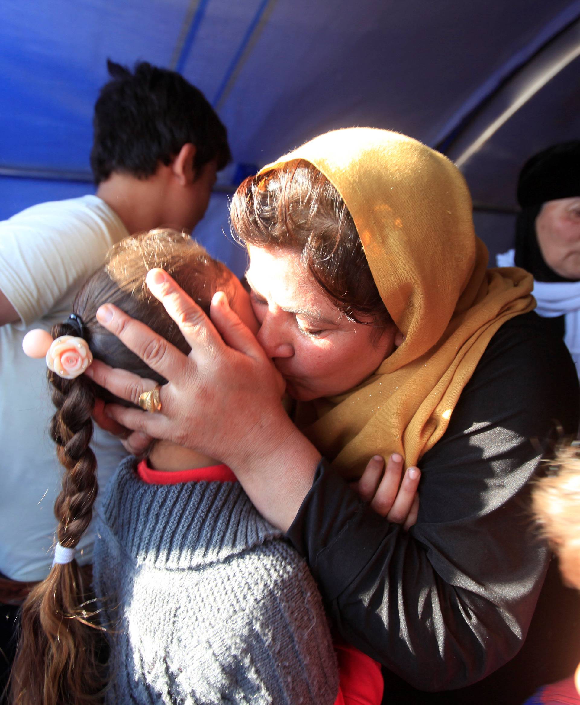 Displaced Iraqi people, who fled from Mosul because of Islamic State violence, meet their relatives in Khazer refugee camp