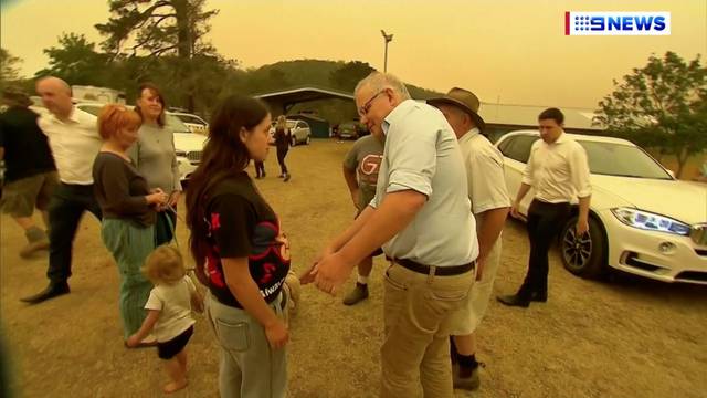 Australia's Prime Minister Scott Morrison attempts to shake a resident's hand during a visit to the bushfire-stricken town of Cobargo