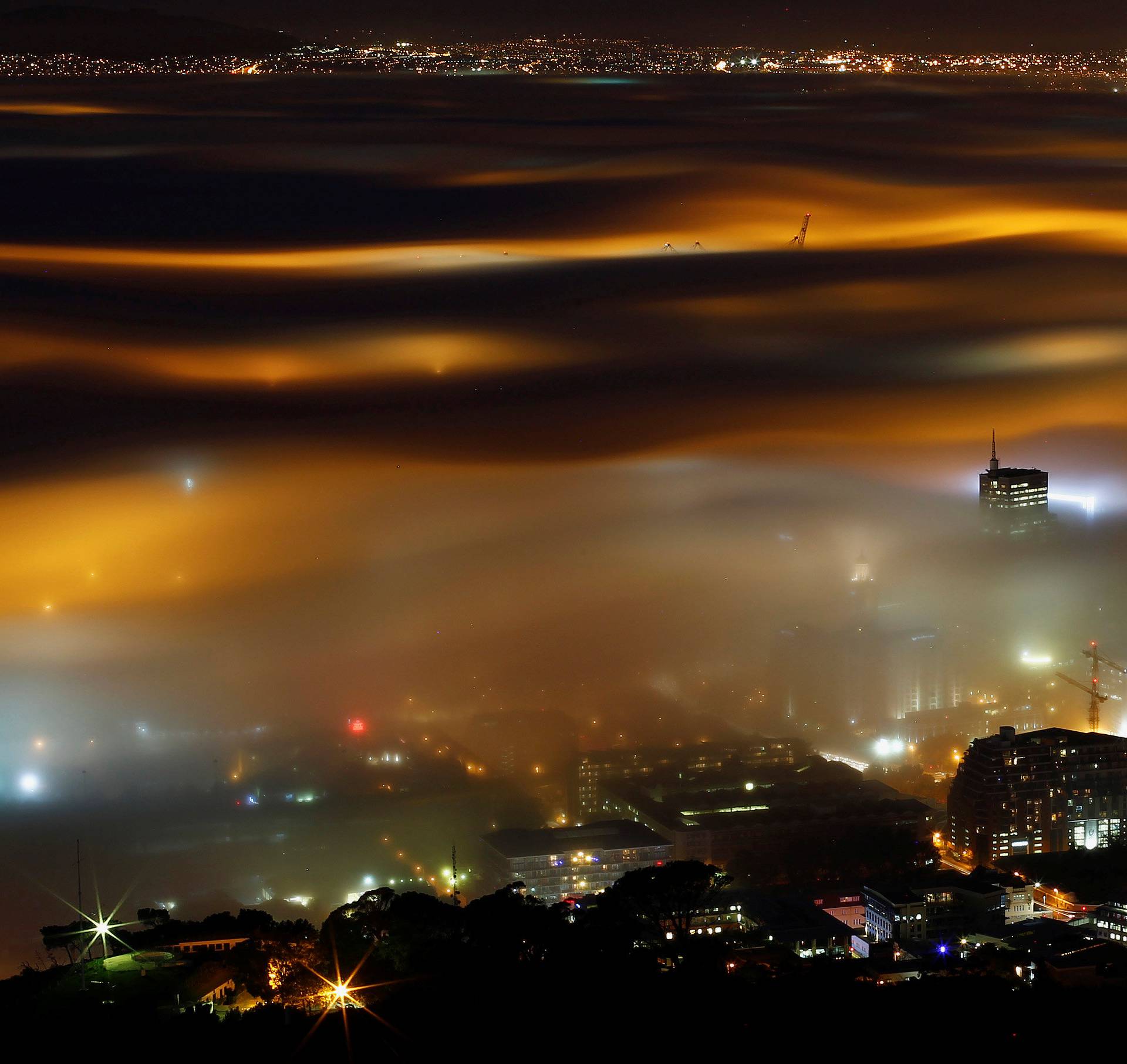 Seasonal fog is illuminated by the lights of  Cape Town harbour as the city prepares for the start of the southern hemisphere winter