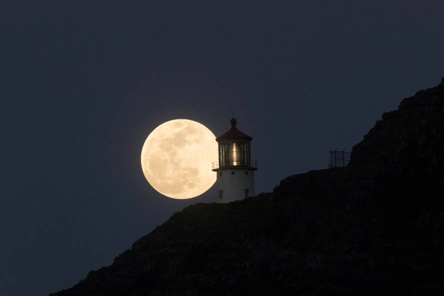 A Super Flower Moon rises over the Makapuu lighthouse in east Oahu, Honolulu