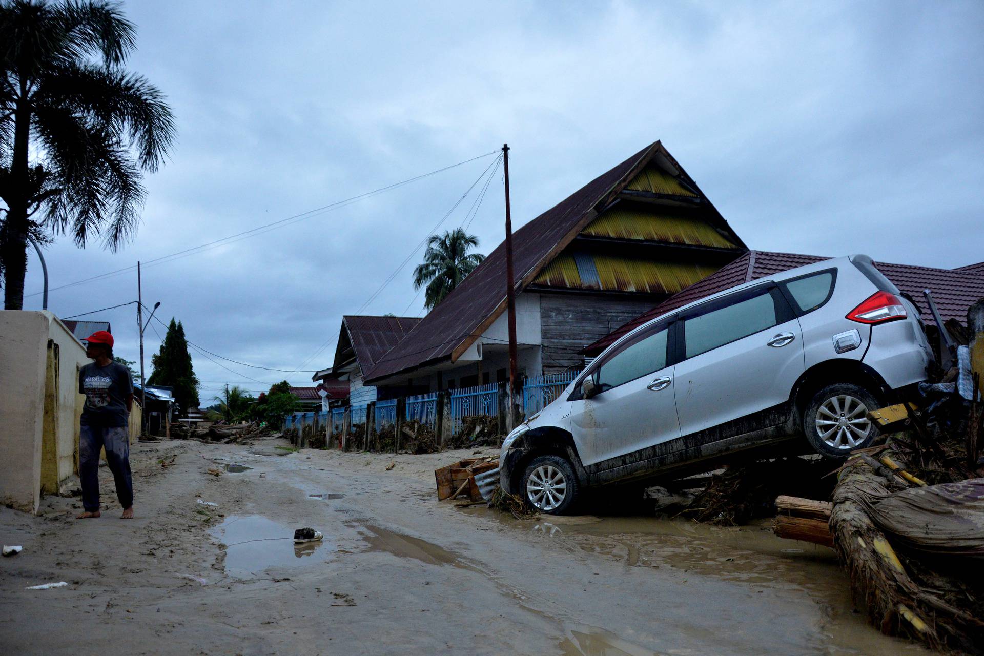 A car is partially covered in mud after flash floods swept through Radda, North Luwu, South Sulawesi