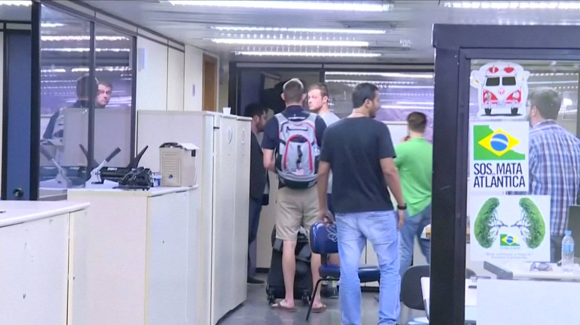 U.S. Olympic swimmers Gunnar Bentz and Jack Conger walk inside the airport police station office at Rio's international airport in this still frame taken from video 