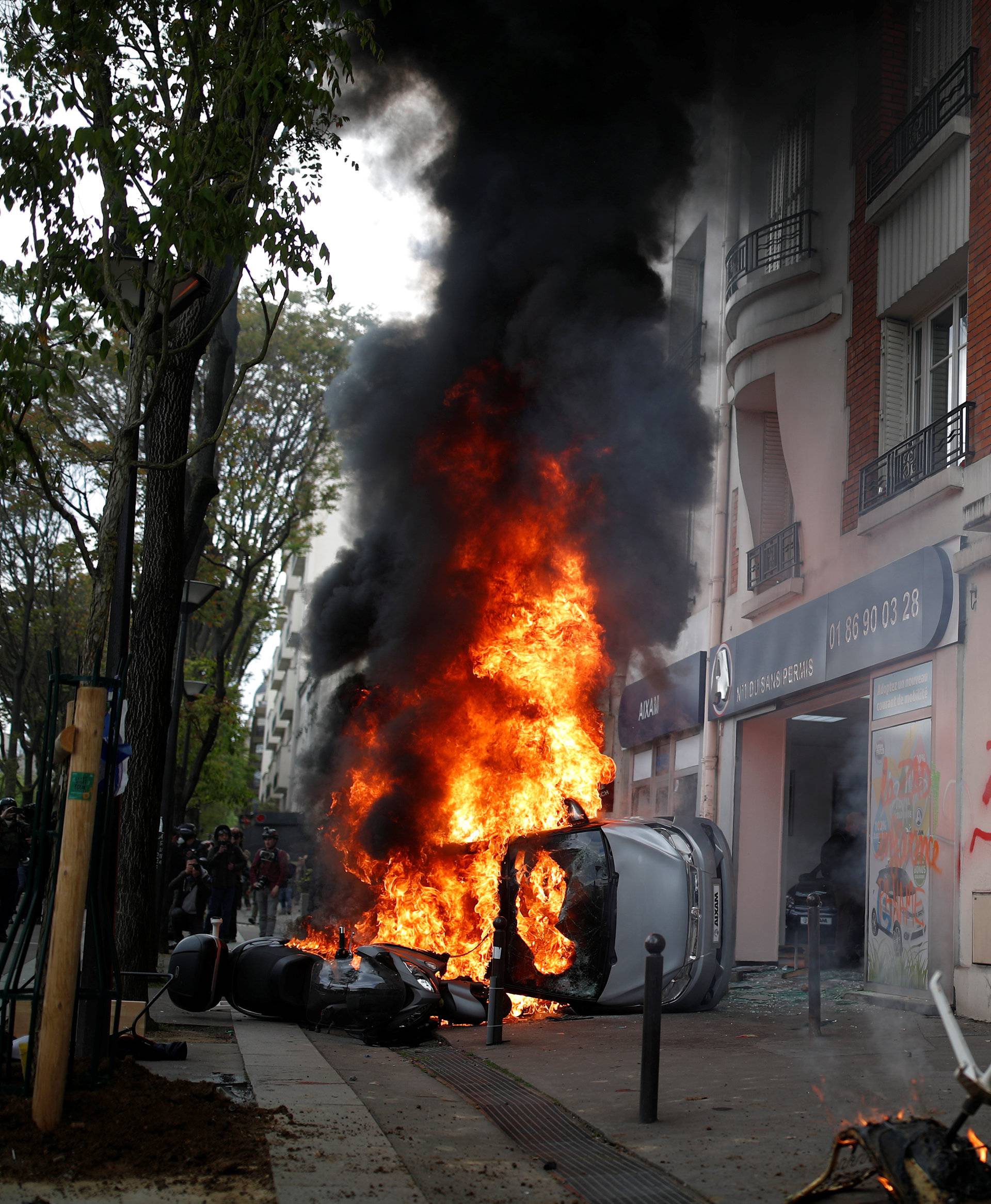 A car burns outside a Renault automobile garage during clashes at the May Day labour union march in Paris