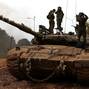 Israeli soldiers stand on top of a tank in northern Israel, near the Israel-Lebanon border