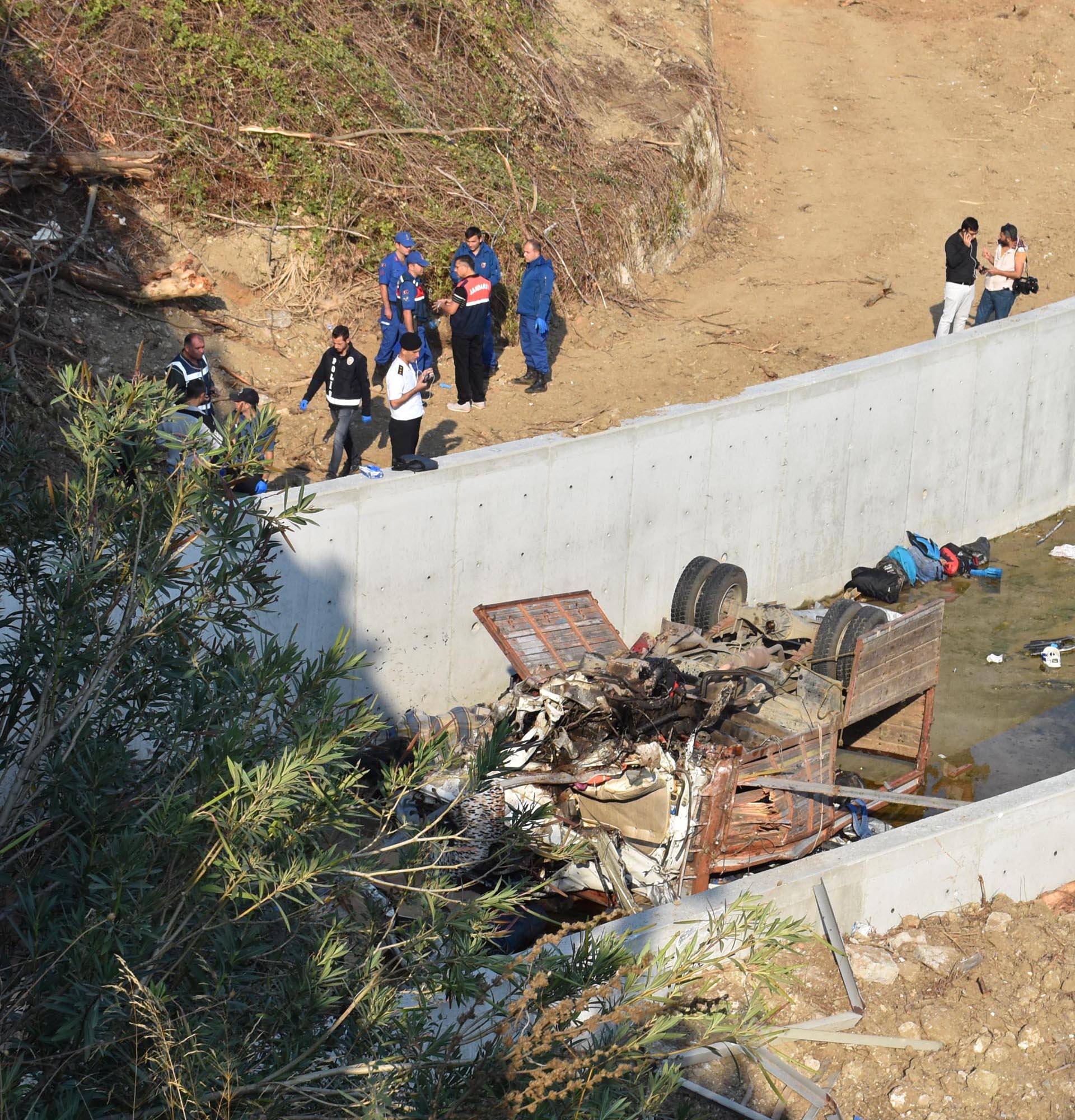 Turkish police forensic experts examine the wreckage of a truck, carrying migrants, after it crashed in Izmir