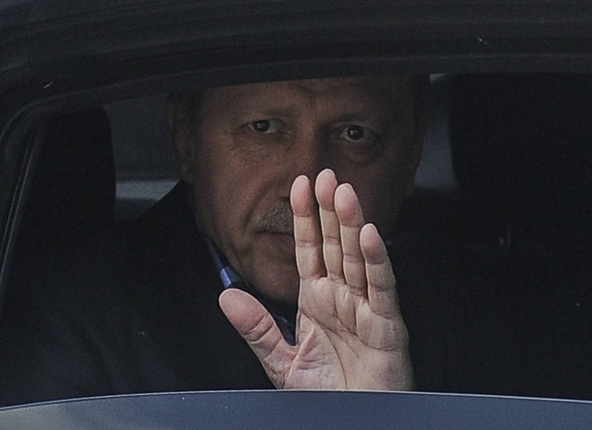 Turkish President Erdogan waves from his car after leaving his residence in Istanbul