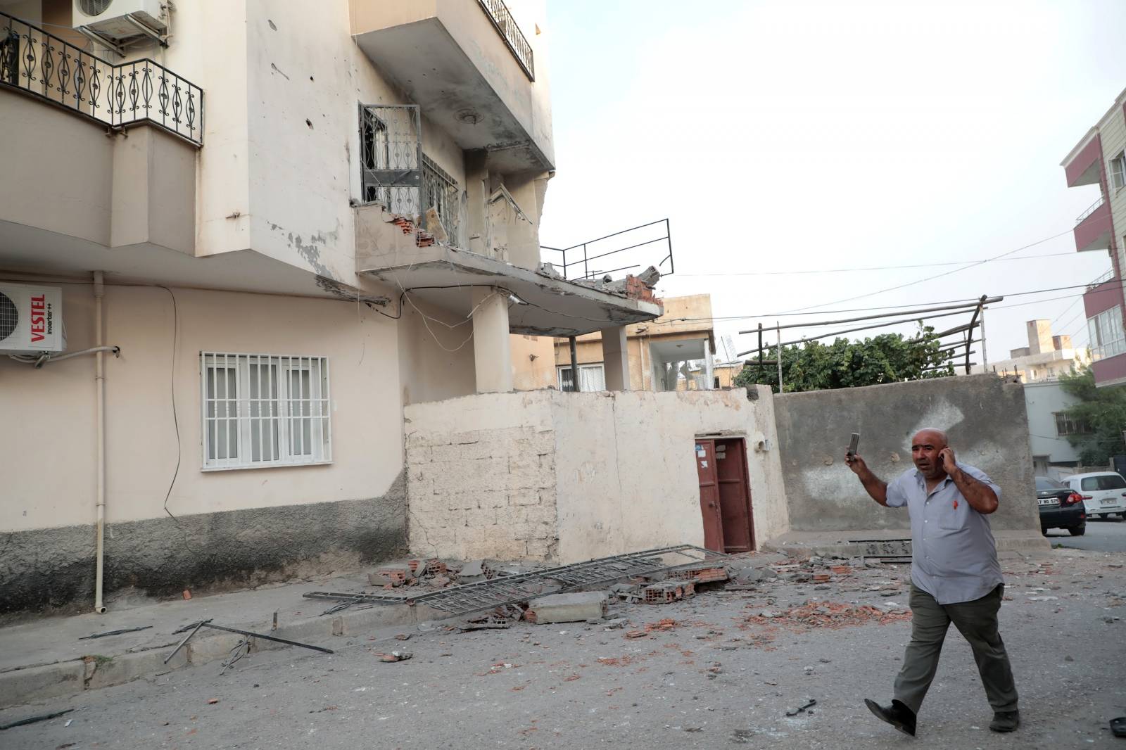 A man reacts after an apartment building hit by a rocket fired from Syria, in Nusaybin