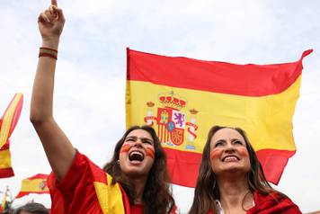 Demonstrators wave Spanish flags and shout in front of city hall during a demonstration in favor of a unified Spain a day before the banned October 1 independence referendum, in Madrid
