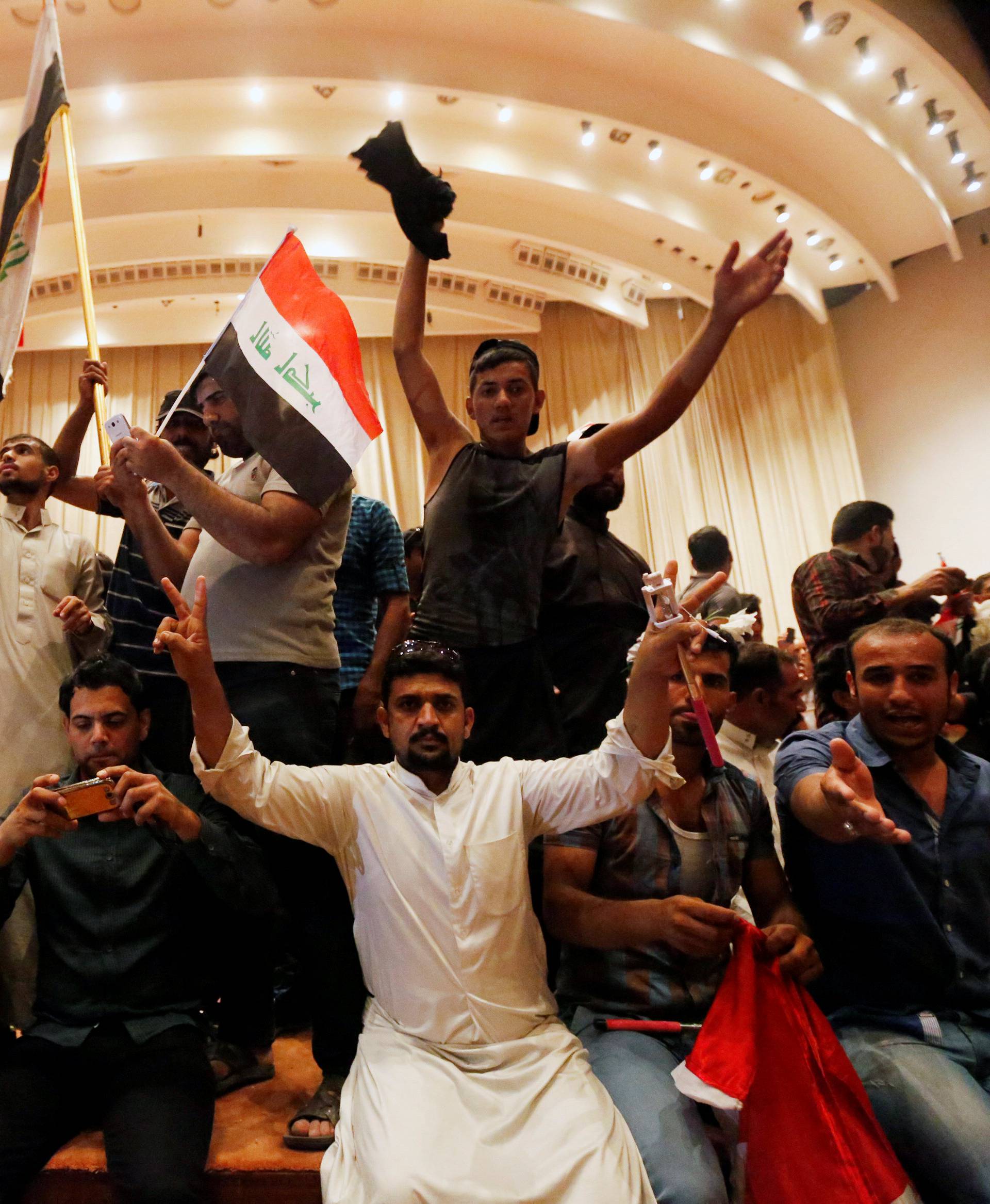 Followers of Iraq's Shi'ite cleric Moqtada al-Sadr are seen in the parliament building after they stormed Baghdad's Green Zone after lawmakers failed to convene for a vote on overhauling the government 