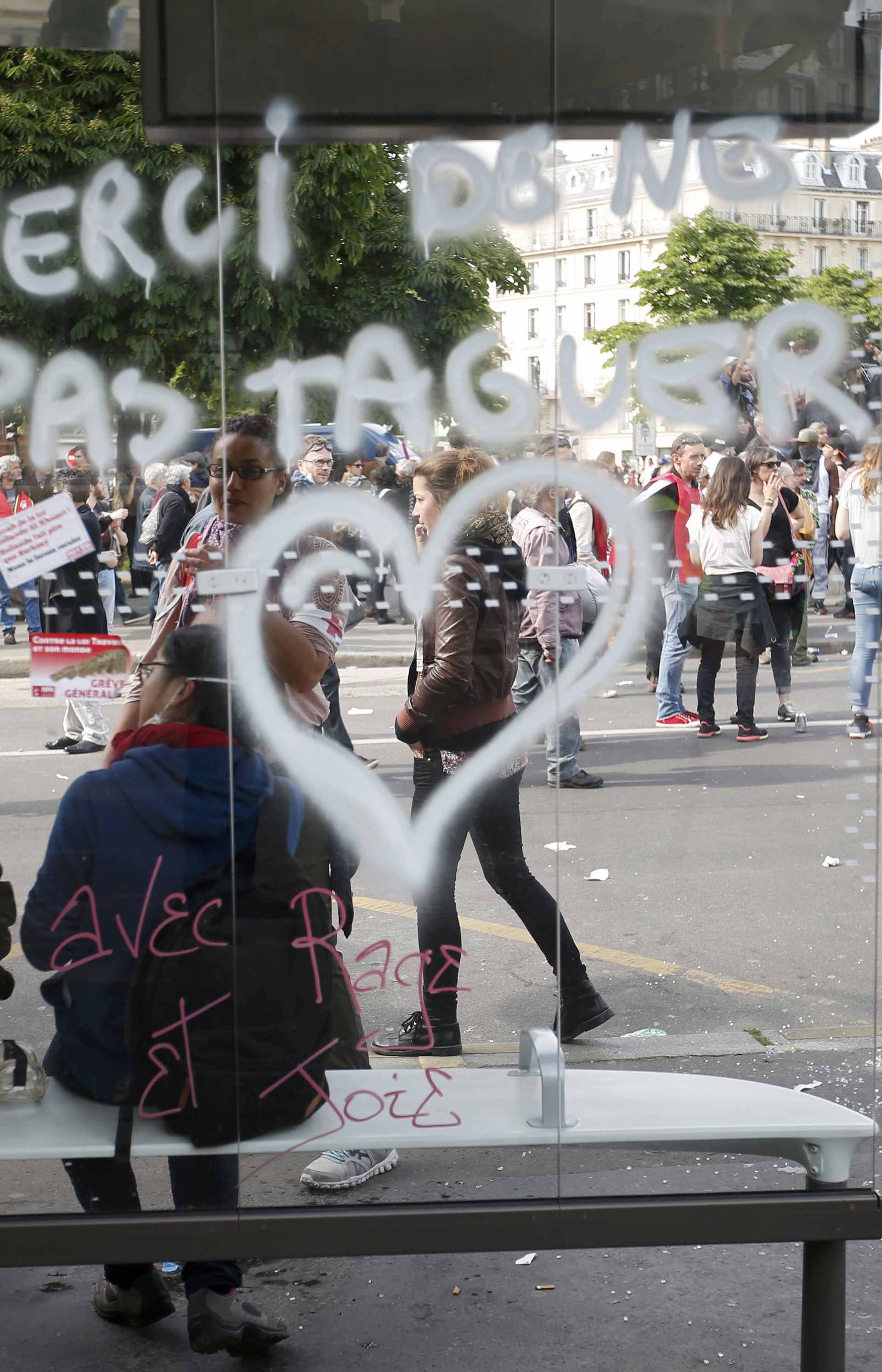 A message is written on a bus stop which was attacked by youths who took part in a demonstration in protest of the government's proposed labor law reforms in Paris