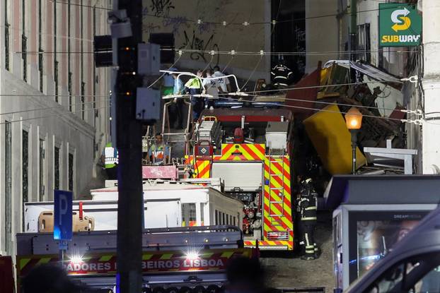 First responders work at the site of a funicular accident in Lisbon