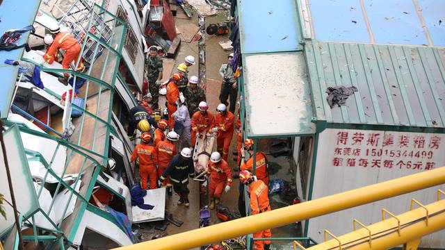 Rescue workers carry a man after a work shed collapsed at a construction site in Dongguan