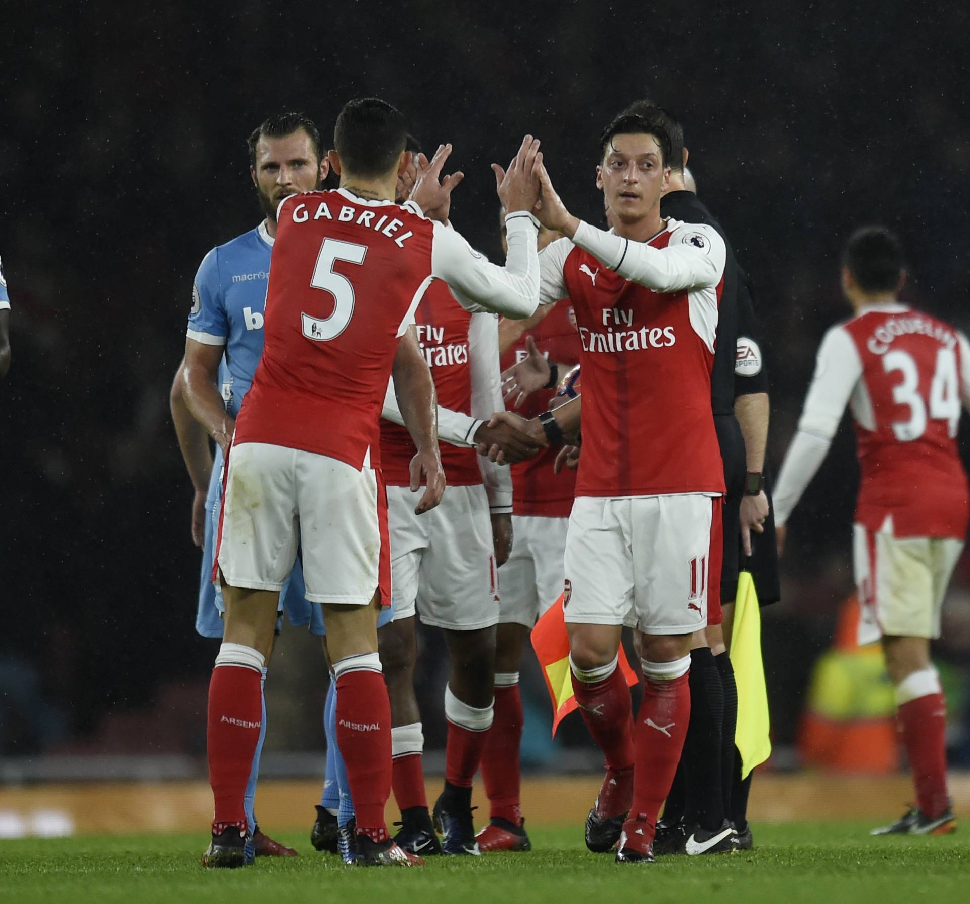 Arsenal's Gabriel Paulista and Mesut Ozil celebrate after the game