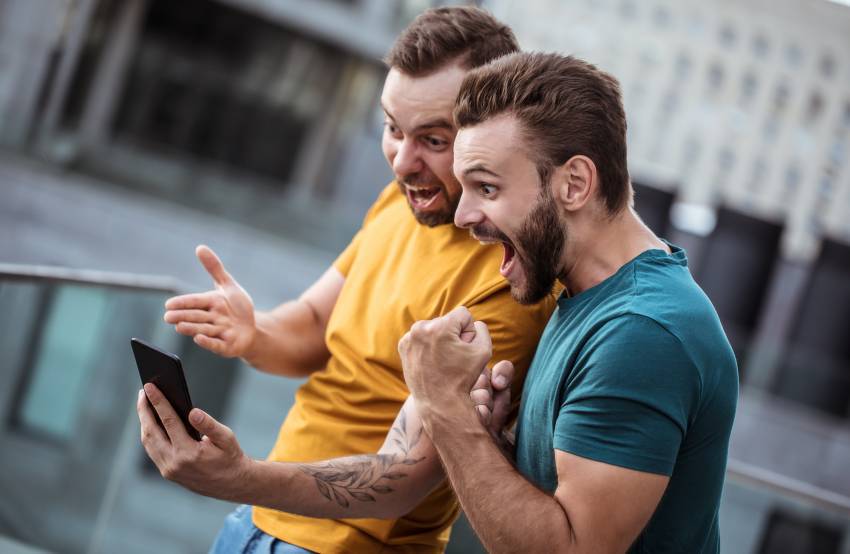 Two happy excited fan friends in euphoria mood after winning in 