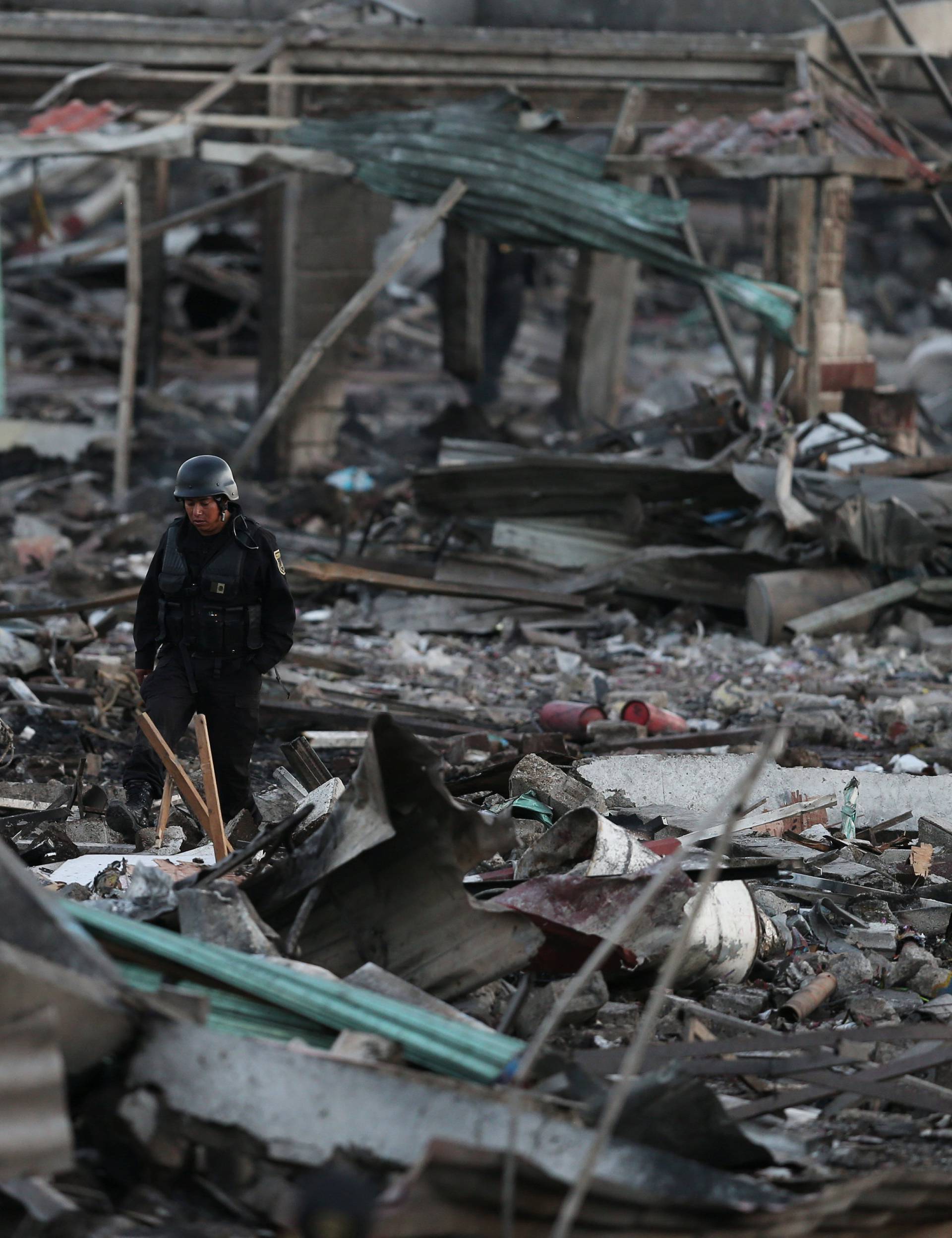 A police officer walks through the remains of houses destroyed in an explosion at the San Pablito fireworks market in Tultepec