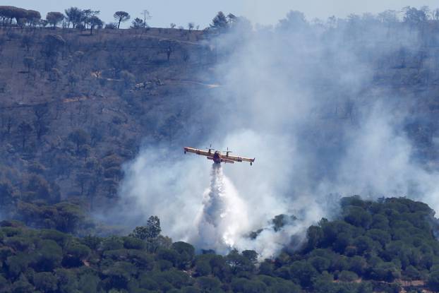 A Canadair firefighting plane drops water to extinguish a forest fire on La Croix-Valmer from Cavalaire-sur-Mer