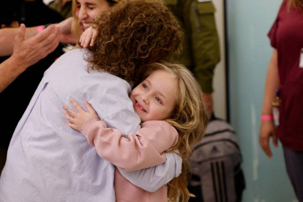 Six year-old Amelia Aloni hugs a person as she and her mother Daniel meet their family members after they returned to Israel last night to the designated complex at the Schneider Children's Medical Center