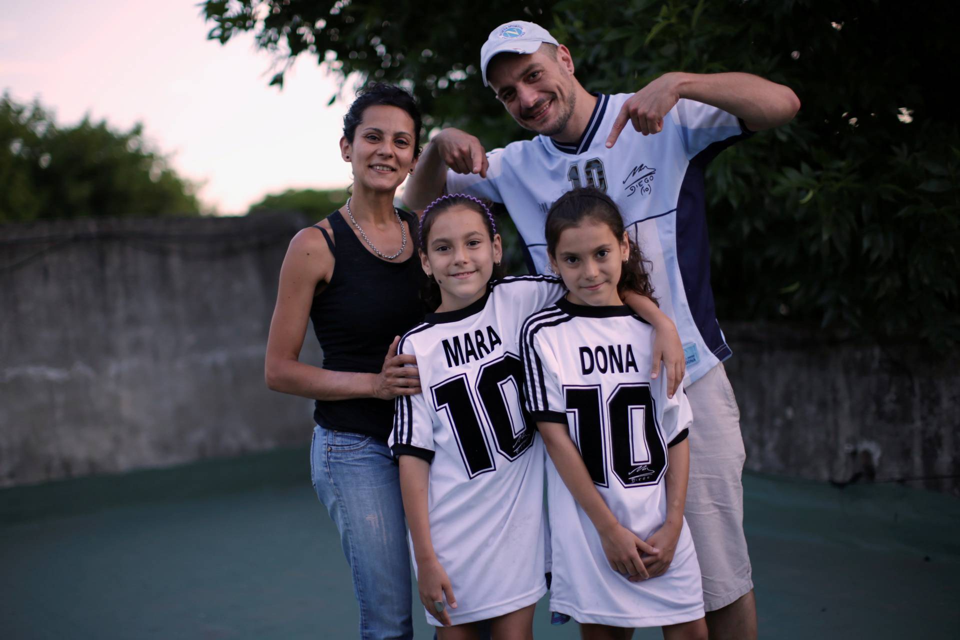 Walter Gaston Rotundo, a devoted Diego Maradona fan who named his twin daughters Mara and Dona after the soccer star, poses with his family in Buenos Aires