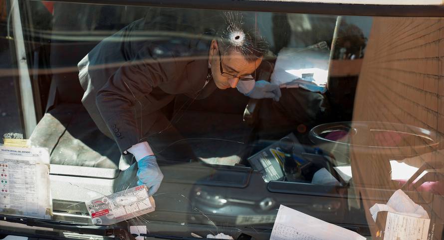 An investigator is seen inside a gas cylinder delivery truck with bullet holes in the windscreen after police fired shots to stop the driver, whom they say had stolen the truck and was driving against traffic, in Barcelona, Spain