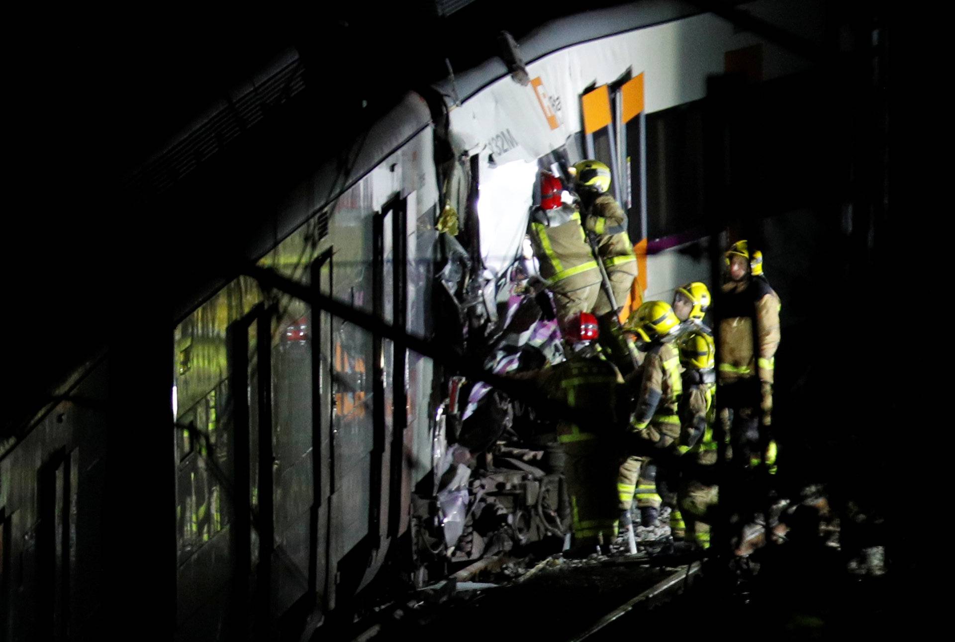 Rescue personnel inspect the site of a train crash near Manresa