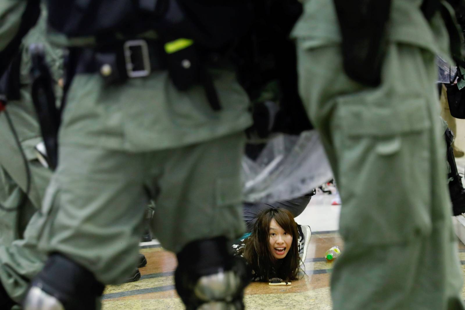 Riot police detain an anti-government protester at a shopping mall in Tai Po, Hong Kong