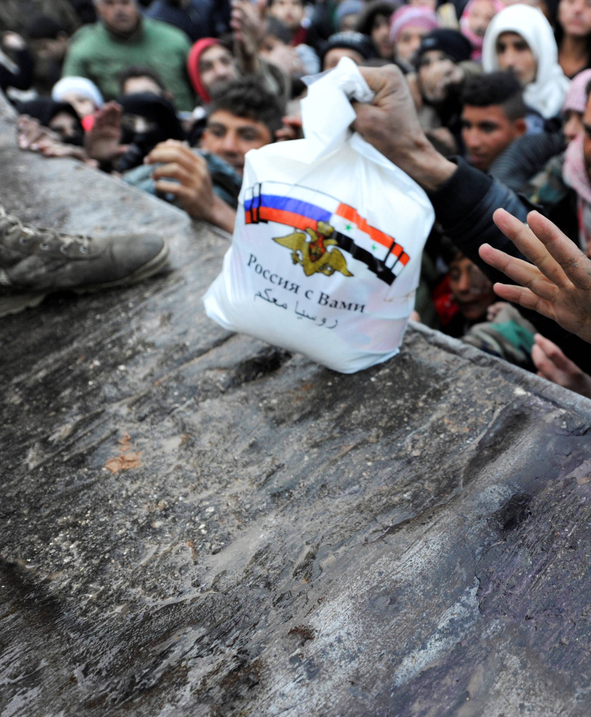 Syrians who have been evacuated from eastern Aleppo, reach out for Russian food aid in government-controlled Jibreen area in Aleppo