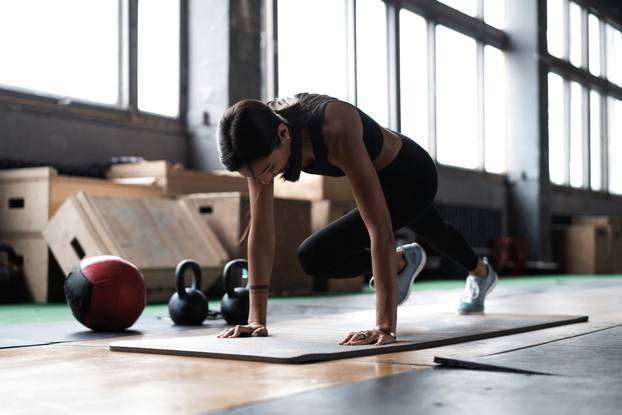 Woman Doing Planks on Gym Floor. Healthy lifestyle concept