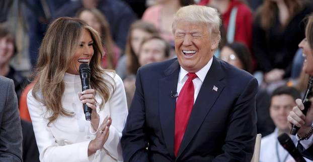 U.S. Republican presidential candidate Donald Trump reacts to an answer his wife Melania gives during an interview on NBC
