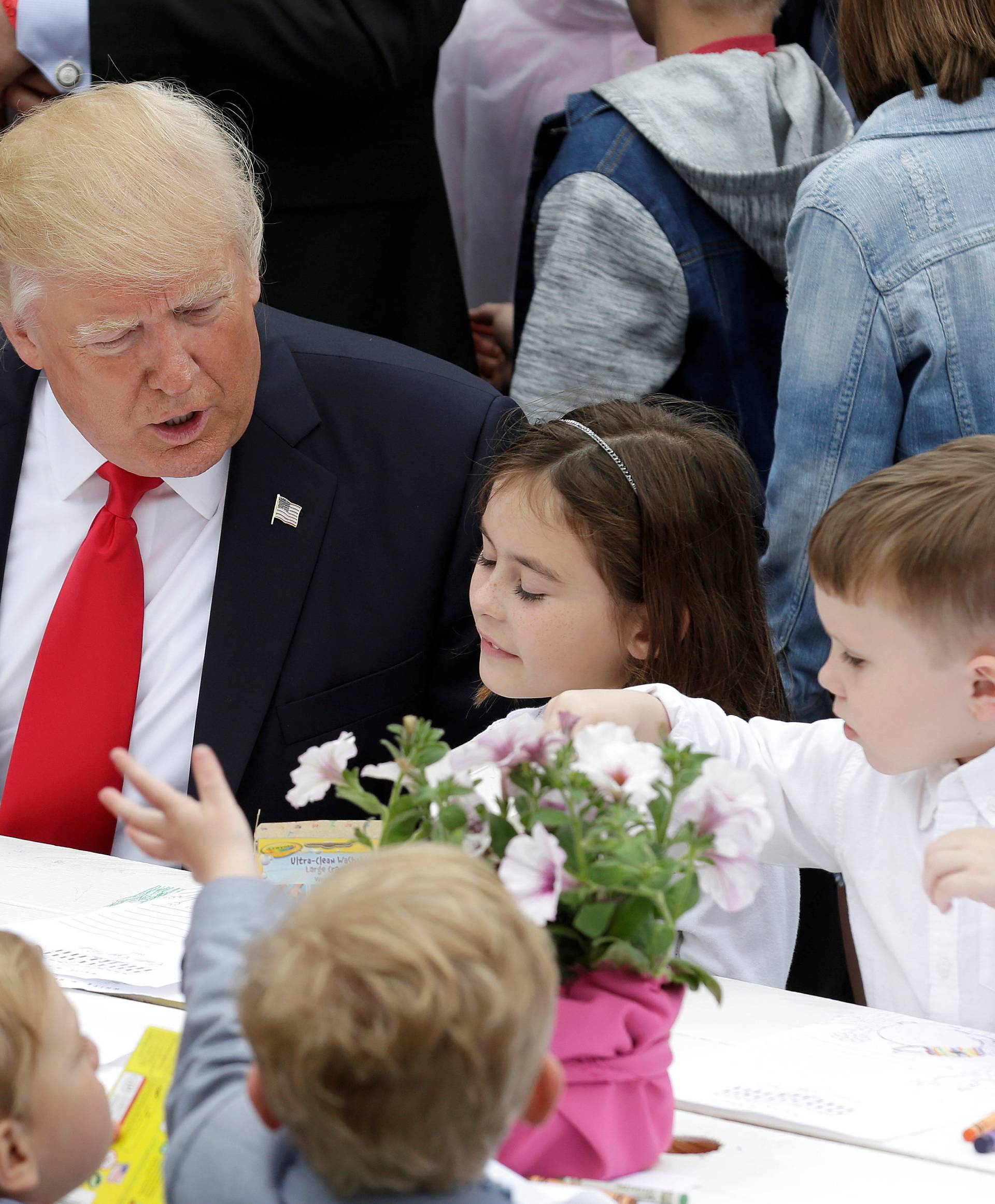 U.S. President Donald Trump speaks with children as they make Easter greeting cards for members of the military at the 139th annual White House Easter Egg Roll on the South Lawn of the White House in Washington