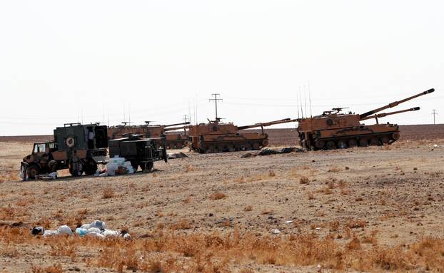 Turkish army vehicles and military personnel are stationed near the Turkish-Syrian border in Sanliurfa province