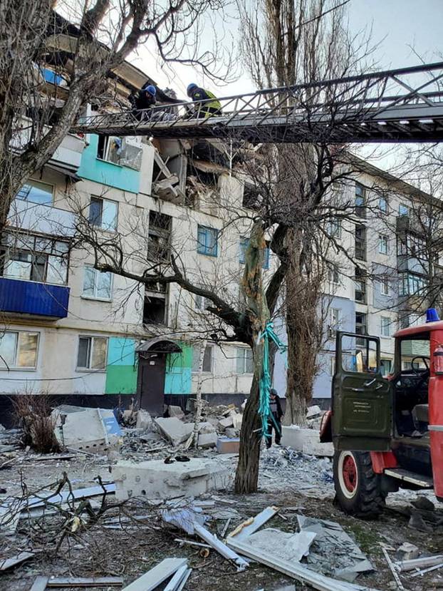 FILE PHOTO: Rescuers evacuate a person from a residential building damaged by military strike in Lysychansk