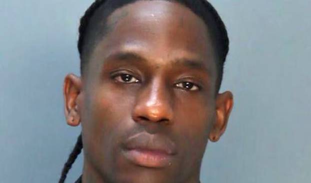 Travis Scott poses for a mugshot after being arrested in Miami