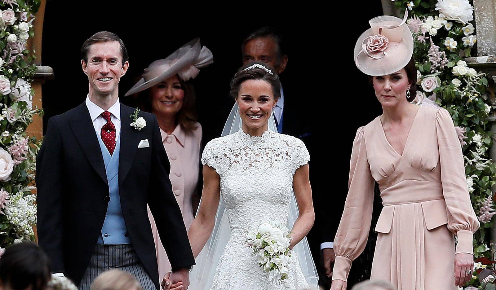 Pippa Middleton and James Matthews smile as they are joined by Britain's Catherine, Duchess of Cambridge after their wedding at St Mark's Church in Englefield