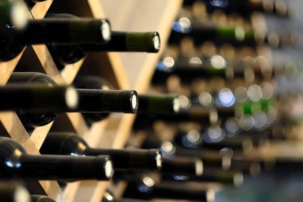 Resting,Wine,Bottles,Stacked,On,Wooden,Racks,In,Cellar