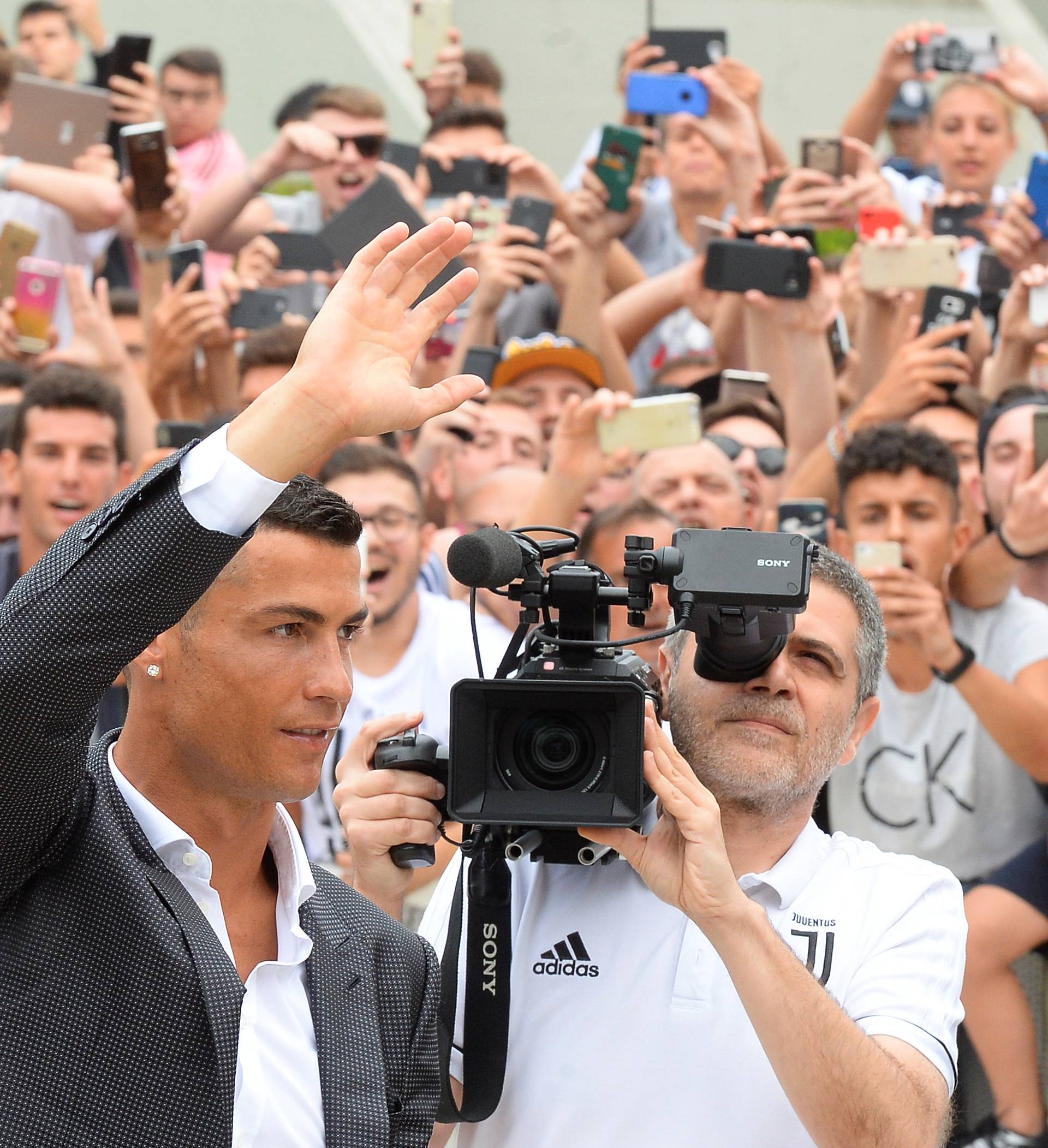Cristiano Ronaldo waves as he arrives at the Juventus' medical center in Turin