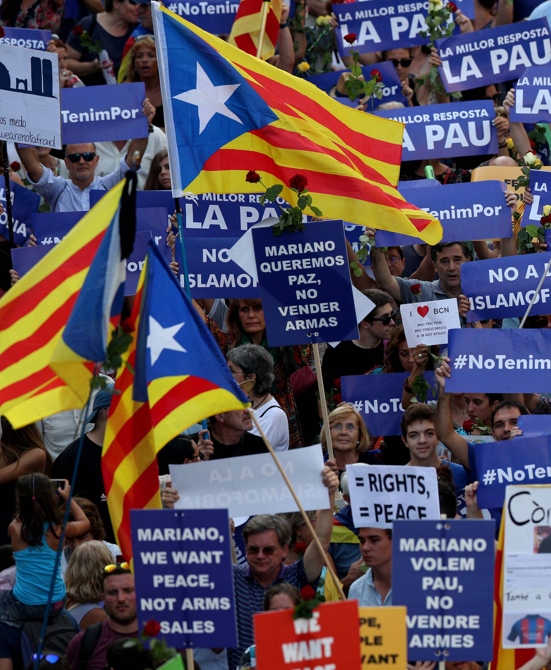 People hold placards and flag as they take part in a march of unity after the attacks last week, in Barcelona, Spain