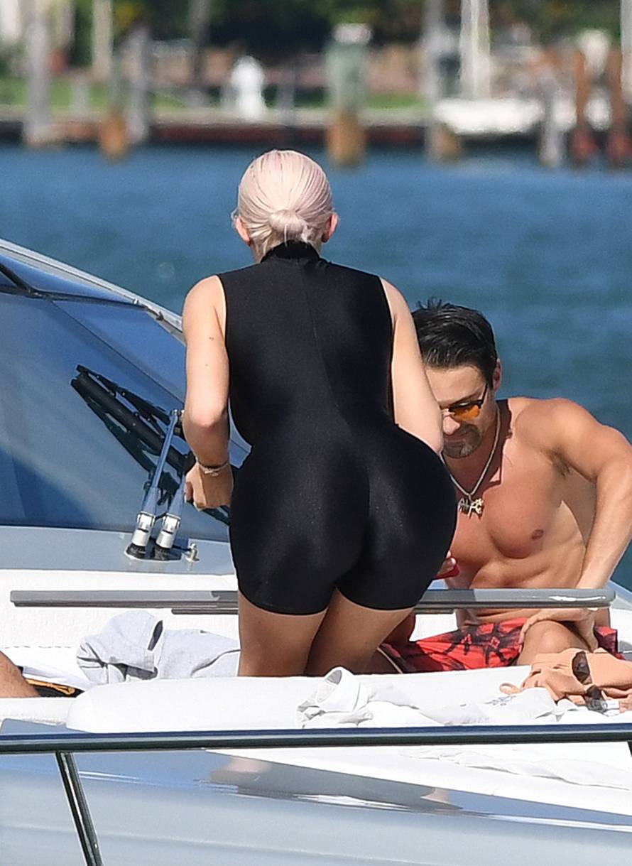 Makeup free Kylie Jenner shows off her famous curves in black spandex as she brings baby daughter Stormi onto Dave Grutman's yacht in Miami