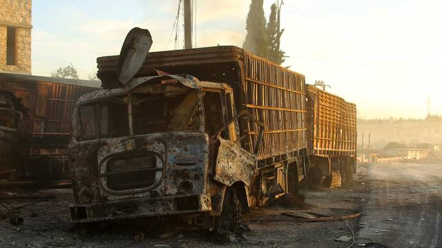 Damaged aid trucks are pictured after an airstrike on the rebel held Urm al-Kubra town