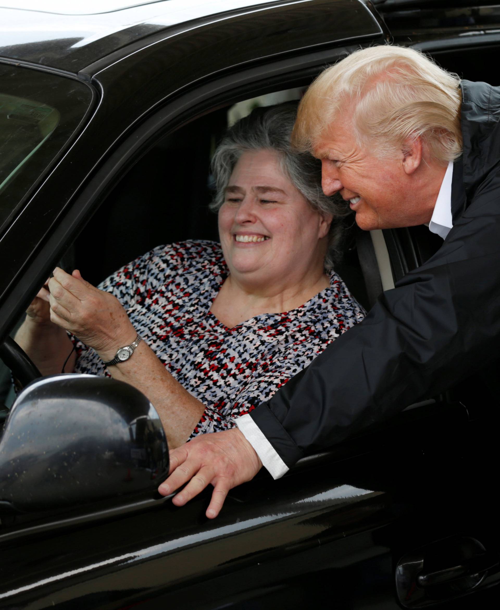 U.S. President Donald Trump poses for a selfie with an unidentified resident waiting in a relief supply drive-thru during a visit with flood survivors and volunteers in the aftermath of Hurricane Harvey in Houston