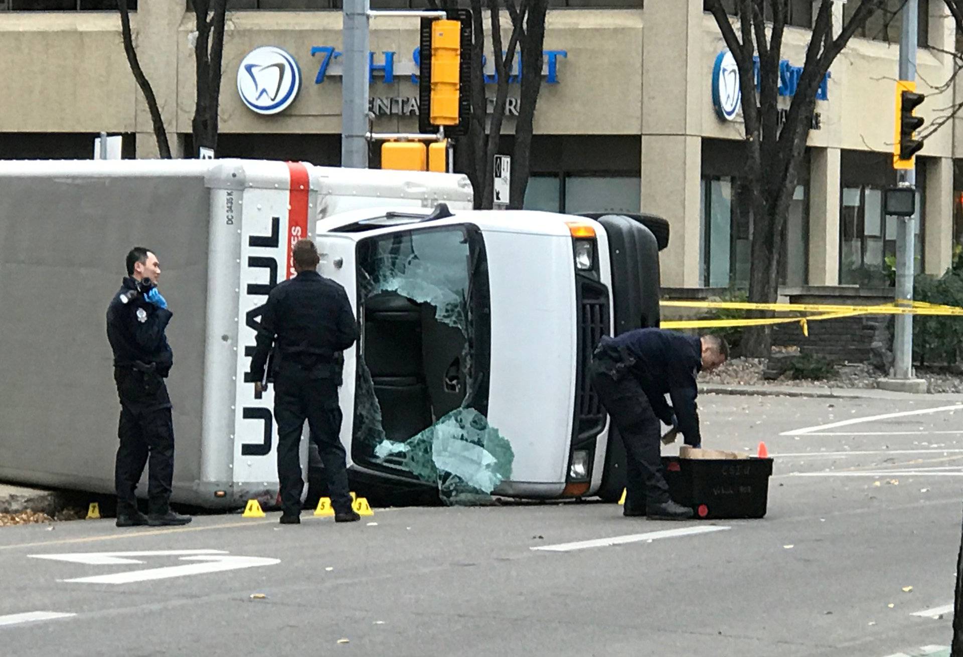 Edmonton Police investigate at the scene where a man hit pedestrians then flipped the U-Haul truck he was driving in Edmonton