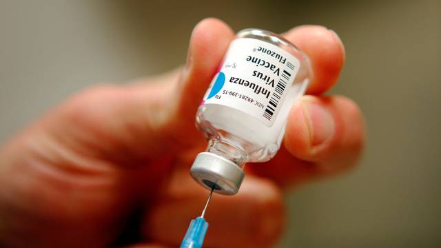 FILE PHOTO: A nurse prepares an injection of the influenza vaccine at Massachusetts General Hospital in Boston, Massachusetts